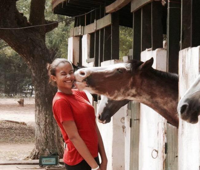 Founder smiling beside a horse early in her equine experience